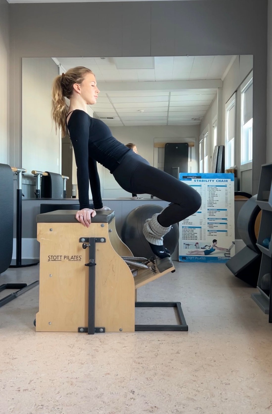 Catherine standing on the Stott chair, eyes closed in focused stillness